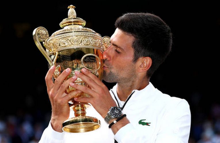 Novak Djokovic, cu trofeul cucerit în la Wimbledon, în 2019