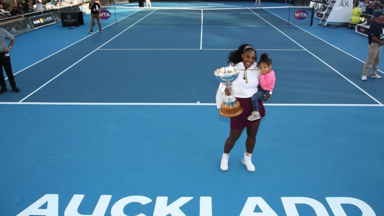 Serena Williams ține fericită în brațe trofeul cucerit la turneul WTA de la Auckland 2020. Fiind primul trofeu cucerit după ce a devenit mamă, în mâna dreaptă ține cupa, iar în mâna stângă o ține în brațe pe fiica sa, Alexis Olympia
